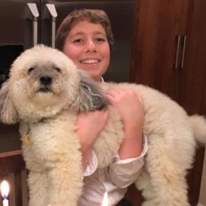 A boy holding his fluffy dog.